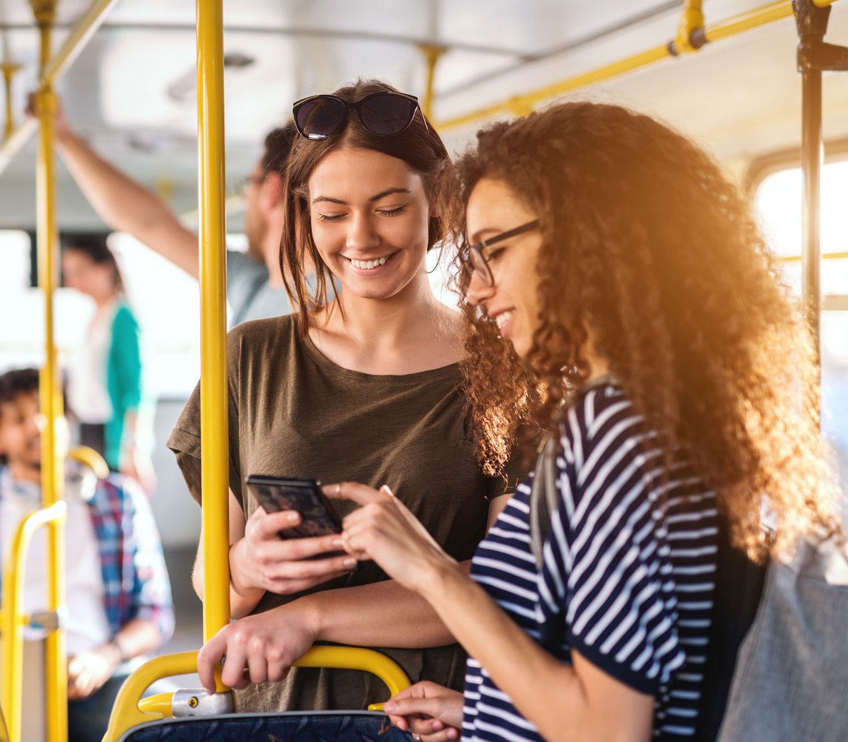 two people on bus using mobile phone