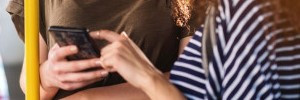 two people on bus using mobile phone