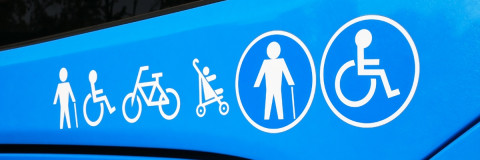 front of a blue bus with accessibility icons